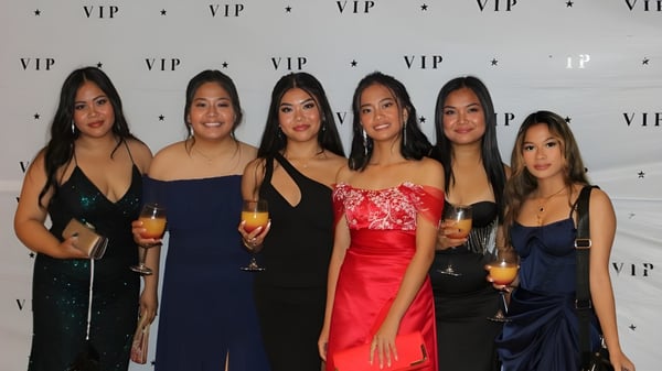 Sechs Schülerinnen des Como Secondary College posieren formal gekleidet vor einem VIP-Hintergrund.