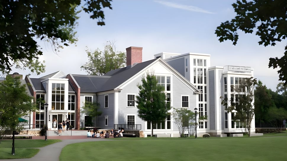 Das mehrstöckige weiße Gebäude der Concord Academy steht umgeben von Bäumen und einem gepflasterten Weg in einer grünen Landschaft.