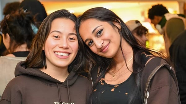 Zwei Schülerinnen der Concord Academy lächeln und posieren zusammen in einem geselligen Umfeld.