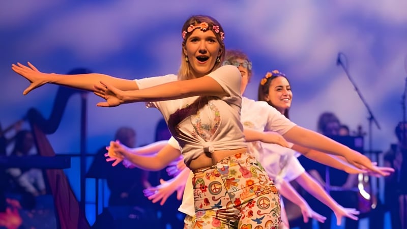 Zwei Frauen führen auf der Bühne am Concord College eine dynamische Tanzperformance in bunten Kostümen auf.