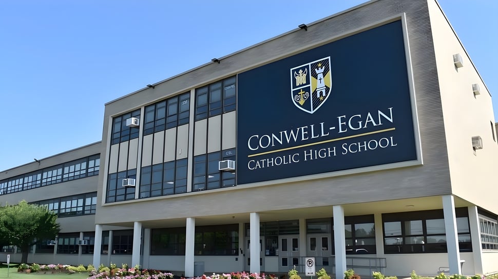 Das mehrstöckige Schulgebäude der Conwell-Egan Catholic High School mit einem gut sichtbaren Namensschild und Logo.