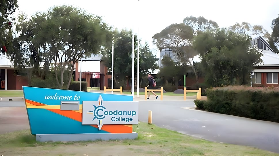 Ein farbenfrohes Willkommensschild steht vor dem Coodanup College umgeben von üppigem Grün und Bäumen.