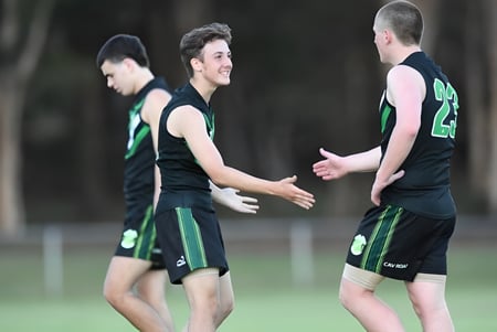 Zwei Schüler der Corinda State High School geben sich auf dem Sportplatz die Hand.
