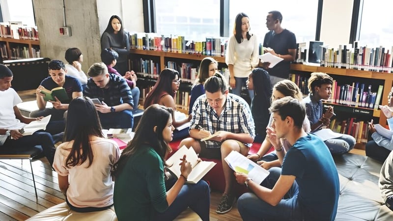 Eine Gruppe Schüler der Cork Educate Together Secondary School diskutiert sitzend auf dem Boden in der Schulbibliothek.