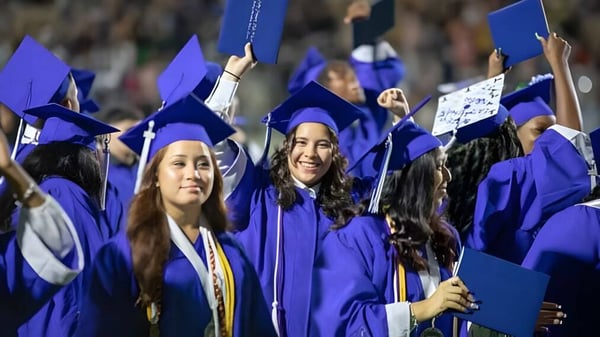 Eine Gruppe von Absolventinnen und Absolventen der Cornafulla National School feiert mit violetten Abschlussroben und Diplomen.