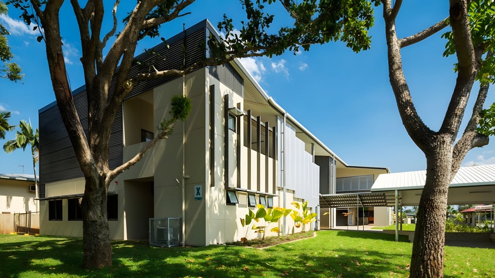 Das mehrstöckige Gebäude der Cornafulla National School ist von Bäumen und einem grünen Rasen umgeben.