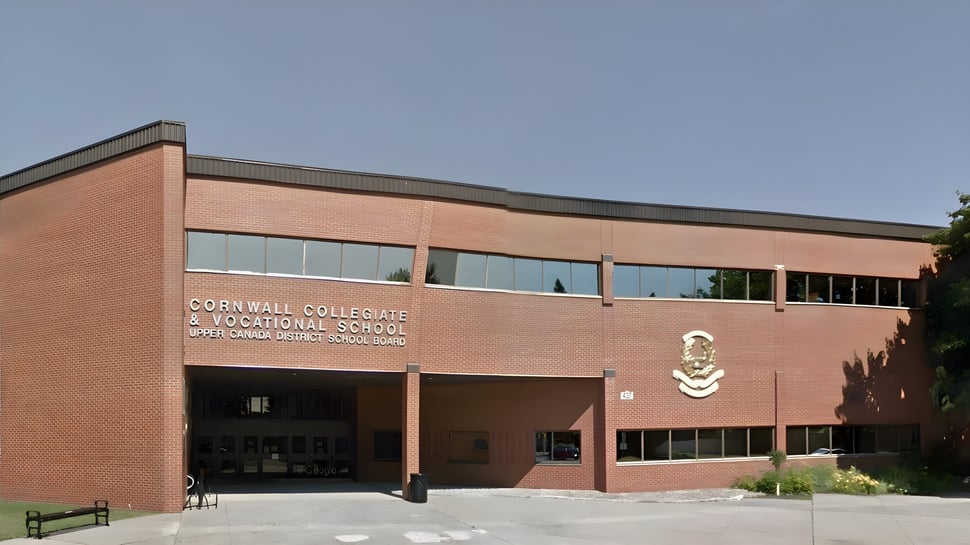 Das große Backsteingebäude der Cornwall Collegiate & Vocational School steht vor einem klaren blauen Himmel.