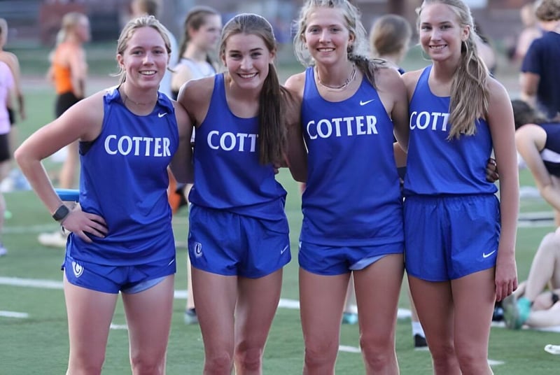 Eine Gruppe junger Athletinnen der Cotter Schools steht gemeinsam auf dem Sportfeld.