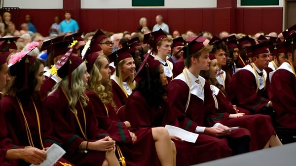 Absolventinnen und Absolventen der Covenant Christian High School tragen in einer Aula ihre Abschlussroben.