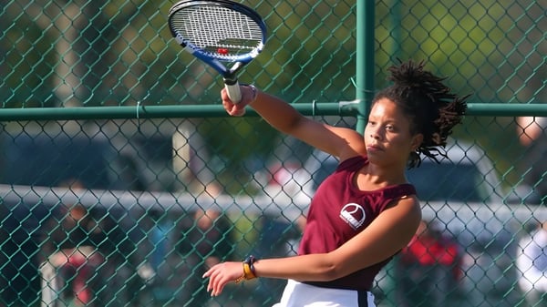 Eine Schülerin der Covenant Christian High School steht mit einem Tennisschläger auf dem Tennisplatz.