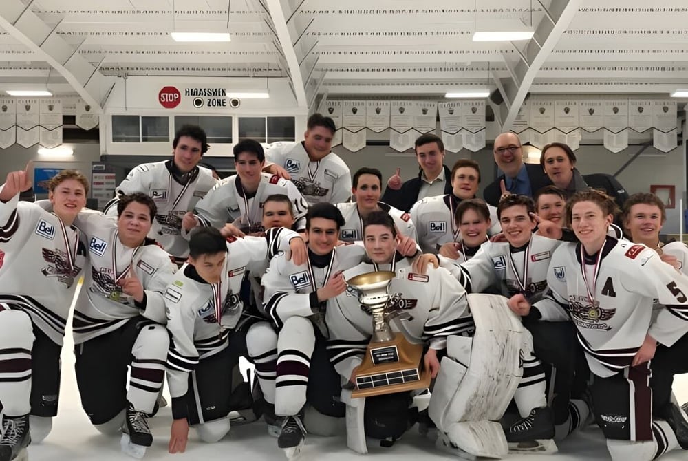 Eine Gruppe von Schülern der Cowichan Secondary School posiert in der Eishockeyhalle gemeinsam mit einem Pokal.