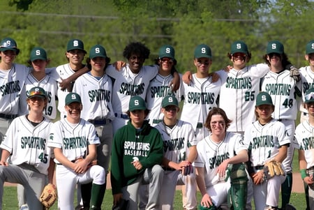 Eine Gruppe von Baseball spielenden Schülerinnen und Schülern auf dem Spielfeld der Craig Kielburger Secondary School.