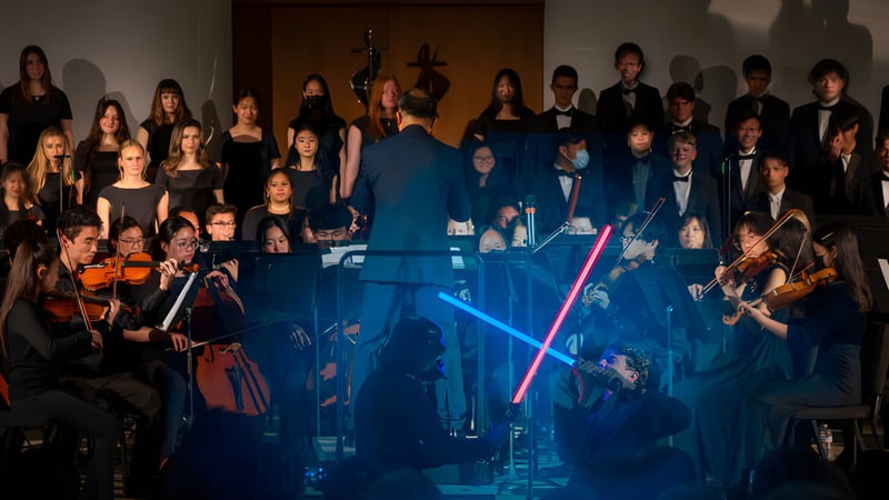 Eine Gruppe von Schülern der Crean Lutheran High School tritt auf einer Bühne mit blauer Beleuchtung auf.