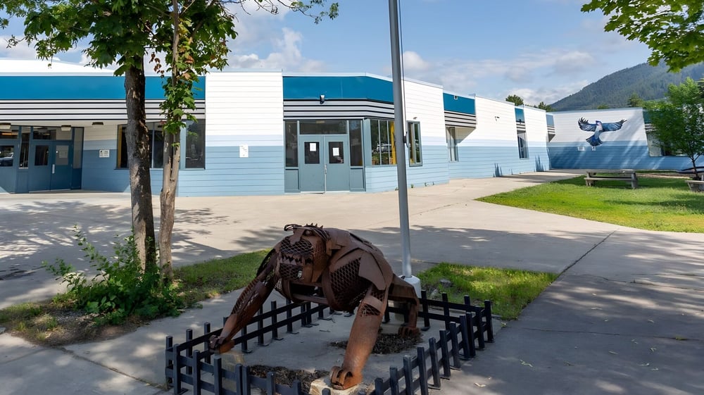 Eine rostige Metallskulptur eines Pferdes steht vor dem Gebäude der Creston Valley Secondary School.
