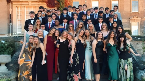 Eine Gruppe von Schülerinnen und Schülern der Culford School steht in formeller Kleidung vor einem historischen Gebäude auf dem Campus.