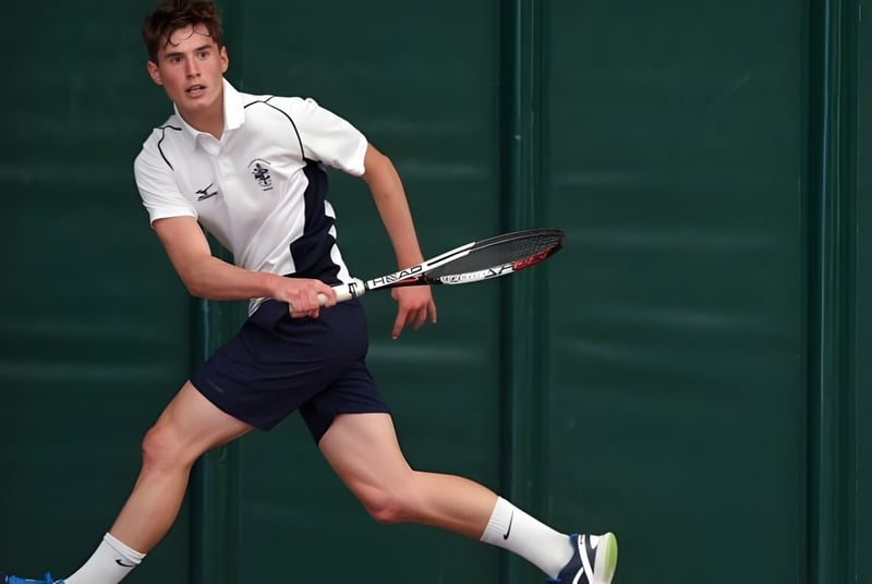 Ein junger Tennisspieler bereitet sich auf dem Tennisplatz der Culford School auf einen Schlag vor.