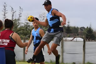Eine Gruppe Schüler spielt Fußball auf dem Sportplatz des Cullinane College vor einem Metallzaun.
