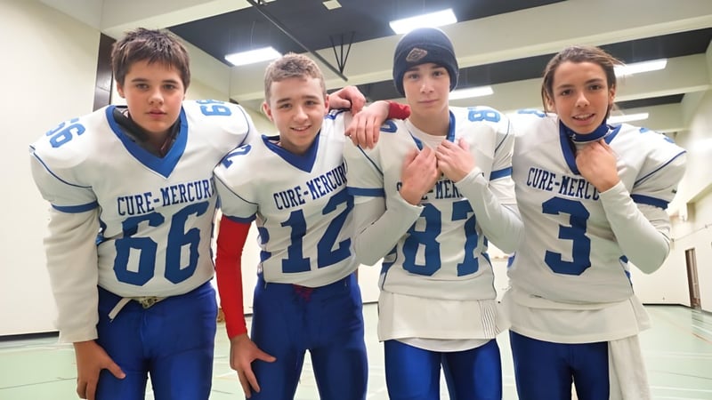 Vier Schüler der École Polyvalente Secondaire Curé-Mercure posieren in der Umkleidekabine in Sporttrikots.