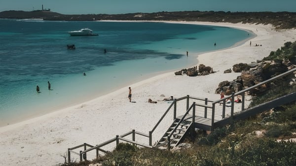 Ein Strand mit klarem türkisfarbenem Wasser und einem kleinen Boot vor dem Campus der Cyril Jackson Senior Campus.