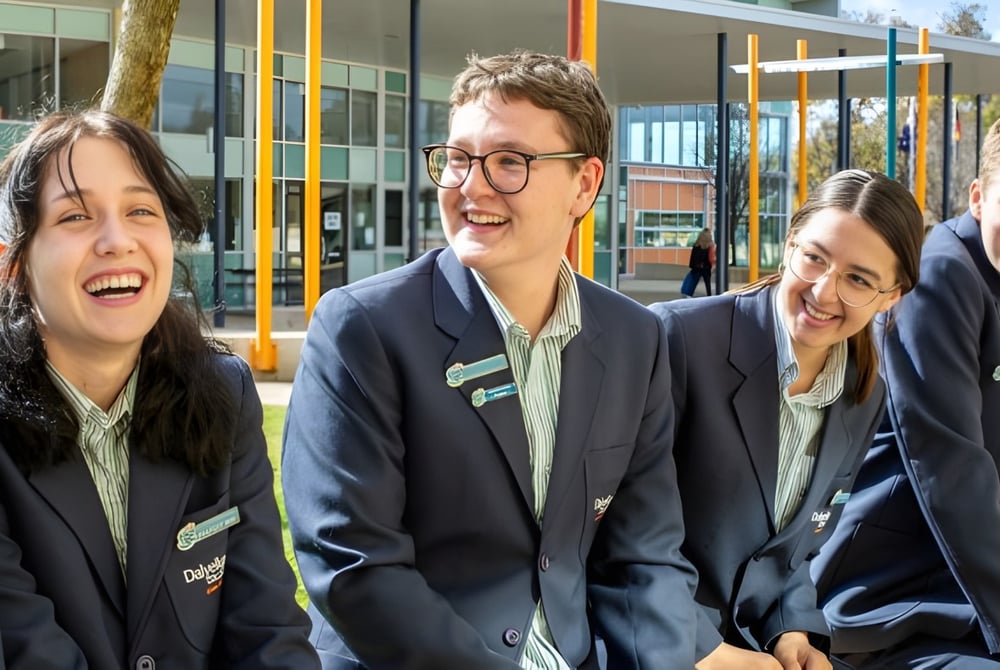 Eine Gruppe von Schülern steht lachend vor dem modernen Glas- und Stahlgebäude des Dalyellup College.