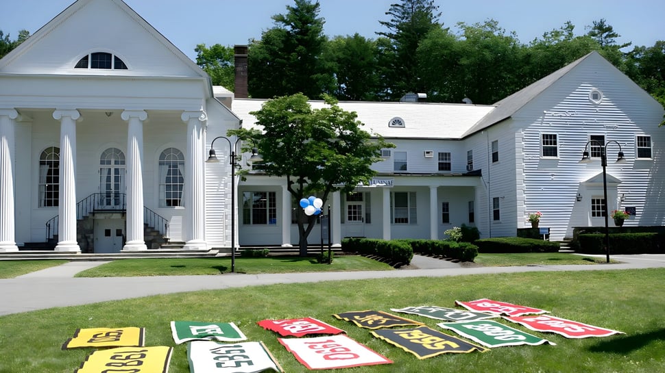 Der gepflegte Rasen und bunte Schilder vor dem kolonialstil Gebäude auf dem Campus der Dana Hall School.