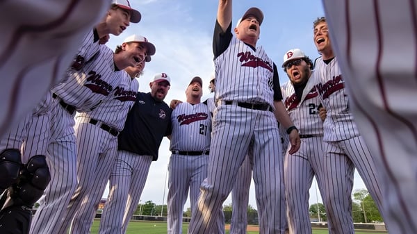Schüler der Danville Community High School feiern gemeinsam auf dem Baseballfeld unter klarem Himmel.
