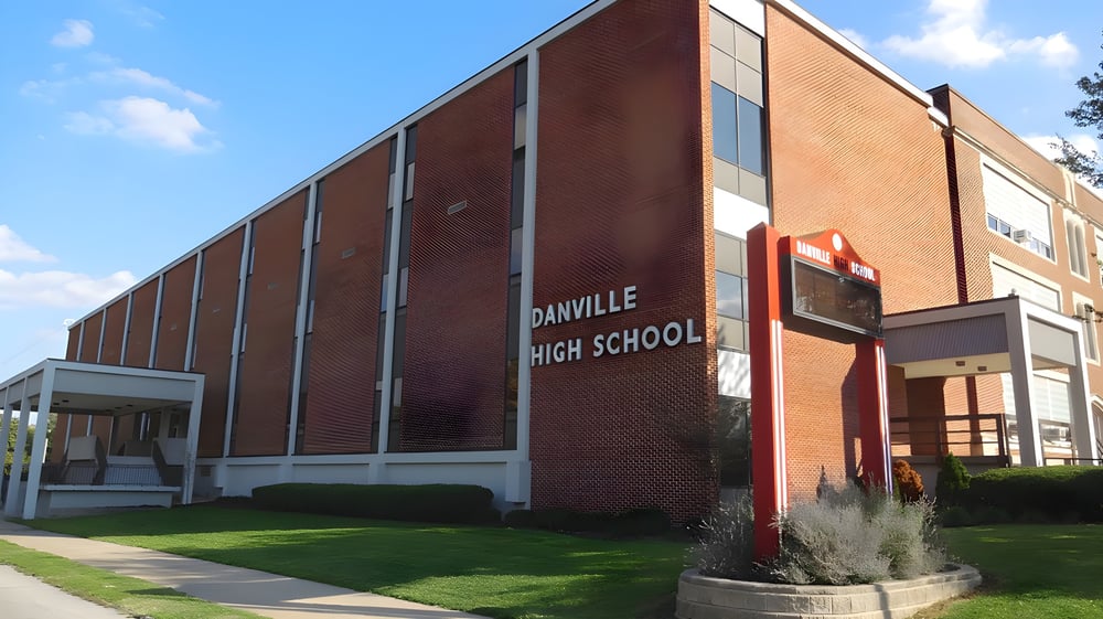 Das große Backsteingebäude der Danville Community High School ist von einem gepflegten Rasen und Landschaftsgestaltung umgeben.