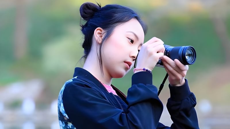 Eine Schülerin der Darlington School macht konzentriert eine Aufnahme mit einer Kamera vor einem unscharfen Naturhintergrund.