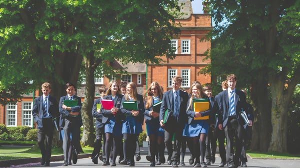 Eine Gruppe Schüler steht vor einem historischen Backsteingebäude auf dem Gelände der Dauntsey’s School.