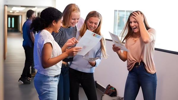 Schüler des David Game College besprechen auf dem Flur gemeinsam Prüfungsergebnisse.