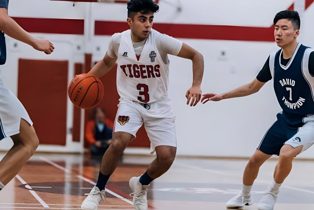 Zwei Schülerinnen und Schüler der David Thompson Secondary School in Vancouver kämpfen um den Ball auf dem Basketballfeld.
