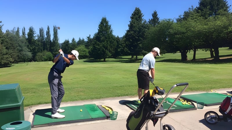Zwei Golfer stehen auf dem Golfplatz im Grünen auf dem Campus der David Thompson Secondary School.