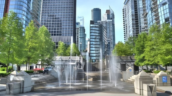 Die urbane Landschaft mit Glas-Hochhäusern und einem Brunnen zeigt die Umgebung der David Thompson Secondary School in Vancouver.