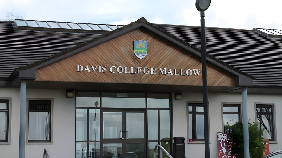 Das Holzgebäude des Davis College Mallow ist von einem gepflasterten Bereich und einer Straßenlaterne umgeben.