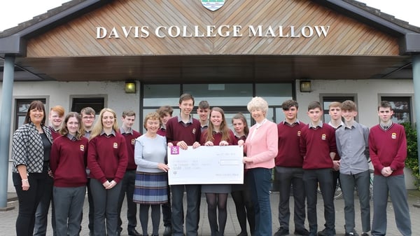 Schüler der Davis College stehen in Schuluniform vor dem Gebäude mit dem Schriftzug Davis College Mallow.