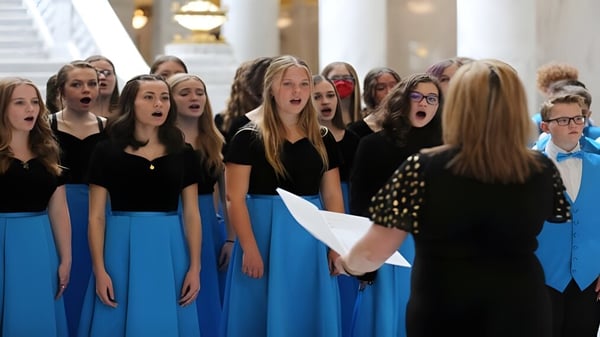 Eine Gruppe Schülerinnen des Davis School District tritt auf einer Bühne mit dekoriertem Hintergrund auf.