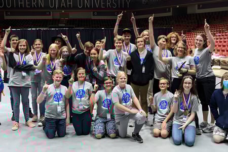 Eine Gruppe Schülerinnen und Schüler des Davis School District posiert gemeinsam in einer großen Halle mit Banner der Southern Utah University im Hintergrund.