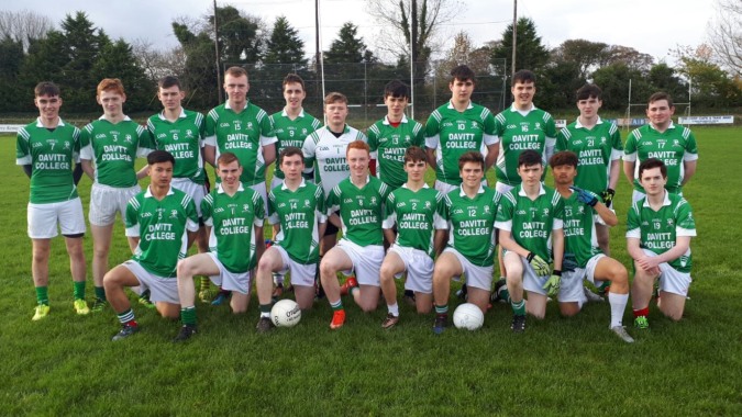 Eine Gruppe junger Fußballspieler in grünen und weißen Trikots posiert auf einem Spielfeld auf dem Campus des Davitt College.