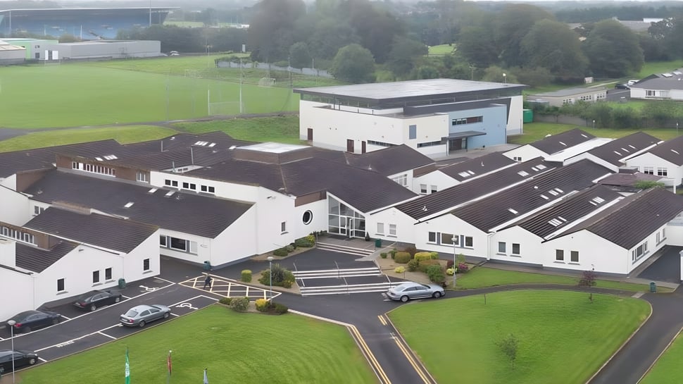 Das Sportfeld und die umliegenden Gebäude auf dem Campus des Davitt College sind von grüner Landschaft umgeben.