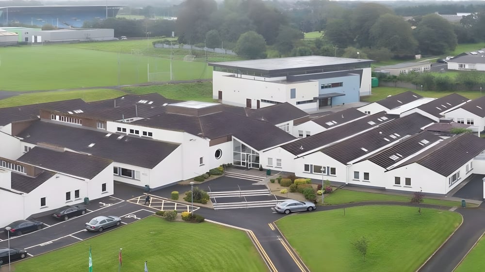 Das Sportfeld und die umliegenden Gebäude auf dem Campus des Davitt College sind von grüner Landschaft umgeben.