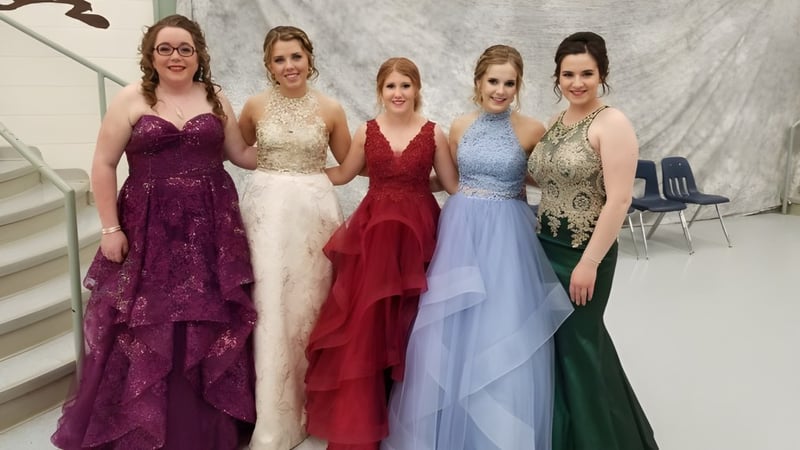 Fünf Schülerinnen der Daysland School posieren in eleganten Kleidern bei einer formellen Veranstaltung.