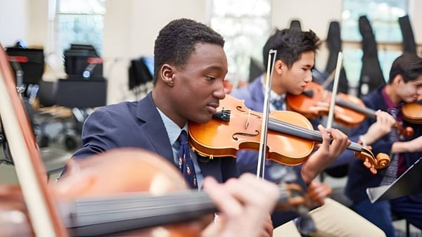 Ein Schüler des De la Salle College in Macroom spielt Violine während einer musikalischen Aufführung mit weiteren Musikern.