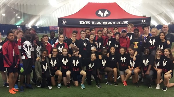 Eine Gruppe von Schülerinnen und Schülern der École secondaire publique De La Salle steht vor einem Banner mit dem Schriftzug De La Salle.