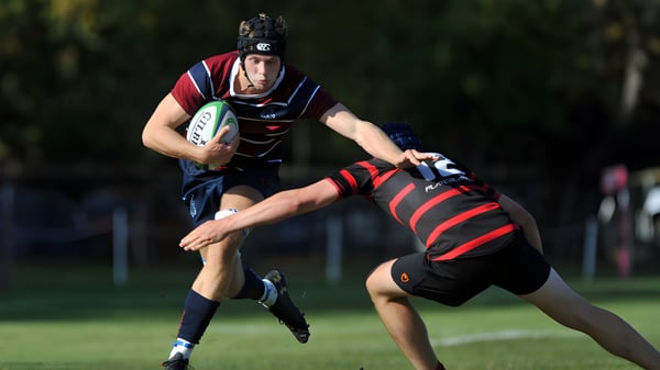 Ein Rugbyspieler der Dean Close School läuft mit dem Ball über ein Grasfeld.