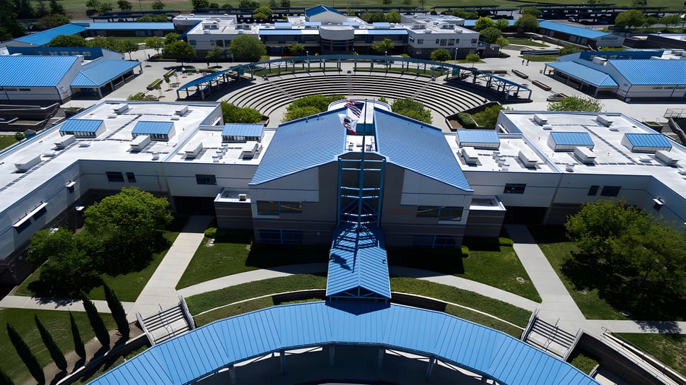 Das moderne Gebäude von Deer Valley Unified ist von grüner Landschaft und einem kreisförmigen Amphitheater umgeben.