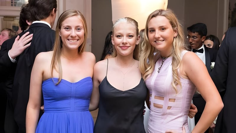 Drei Schülerinnen der Deerfield Academy posieren gemeinsam bei einer Veranstaltung auf dem roten Teppich.