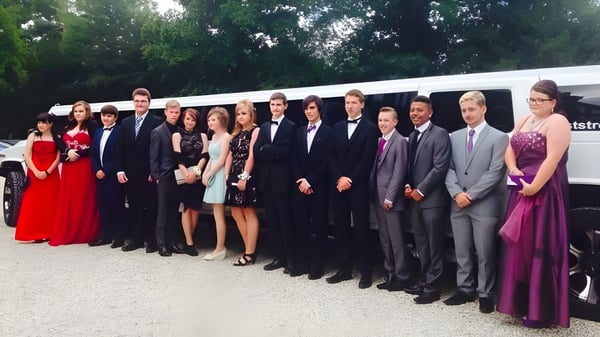 Eine Gruppe von Schülerinnen und Schülern der Denefield School steht formell gekleidet auf einer Wiese mit Bäumen im Hintergrund.