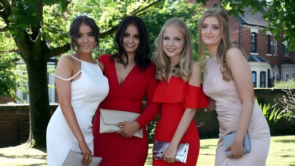 Vier junge Frauen stehen gemeinsam im grünen Außenbereich auf dem Campus des Denstone College und posieren für ein Gruppenfoto.