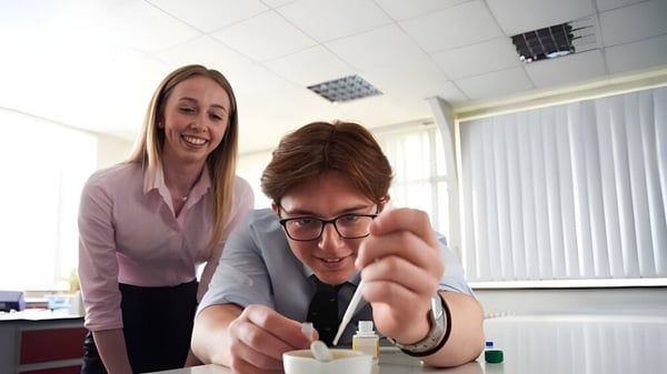 Zwei Personen interagieren freundlich in einem Büro auf dem Campus des Denstone College.