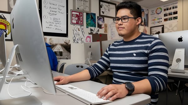 Ein Schüler des Denver Public School District sitzt konzentriert an einem Computer in einem Raum mit verschiedenen Kunstwerken.